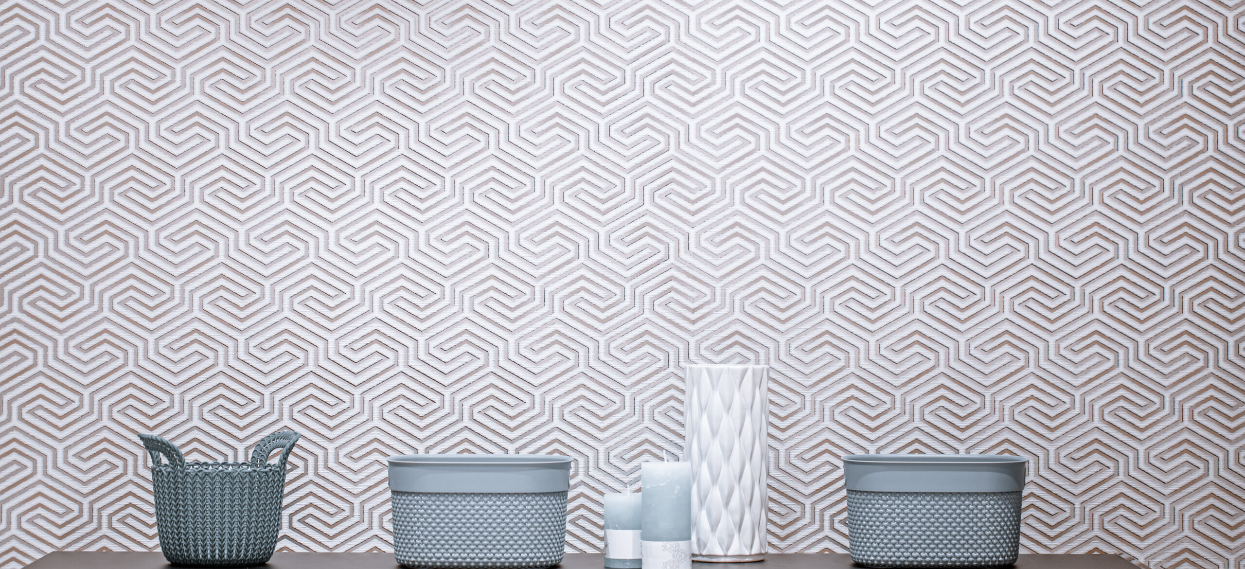 Interior design with decorative items on the table. Beautiful baskets and decorative elements on a light wall background.