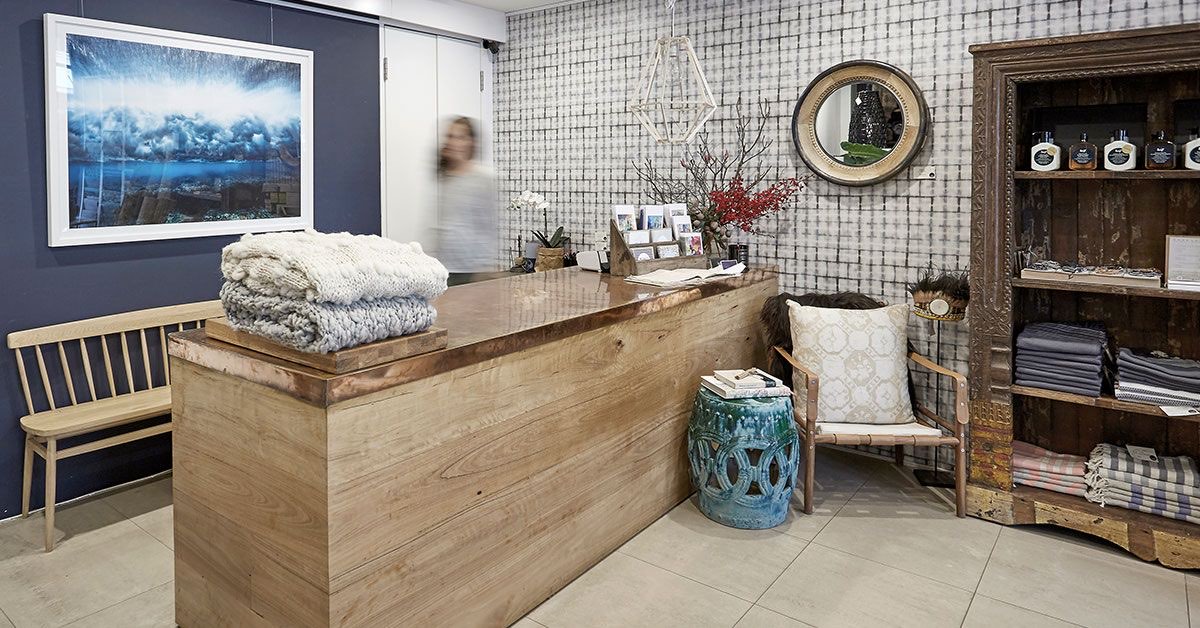 Textured contract wallcovering behind a retail boutique reception, installed by Mancini Wallpapers
