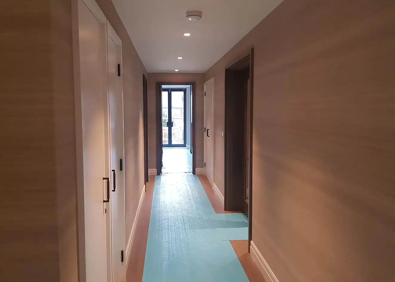 Grasscloth hallway with paneled doors, luxury home wallcovering installation, Utah