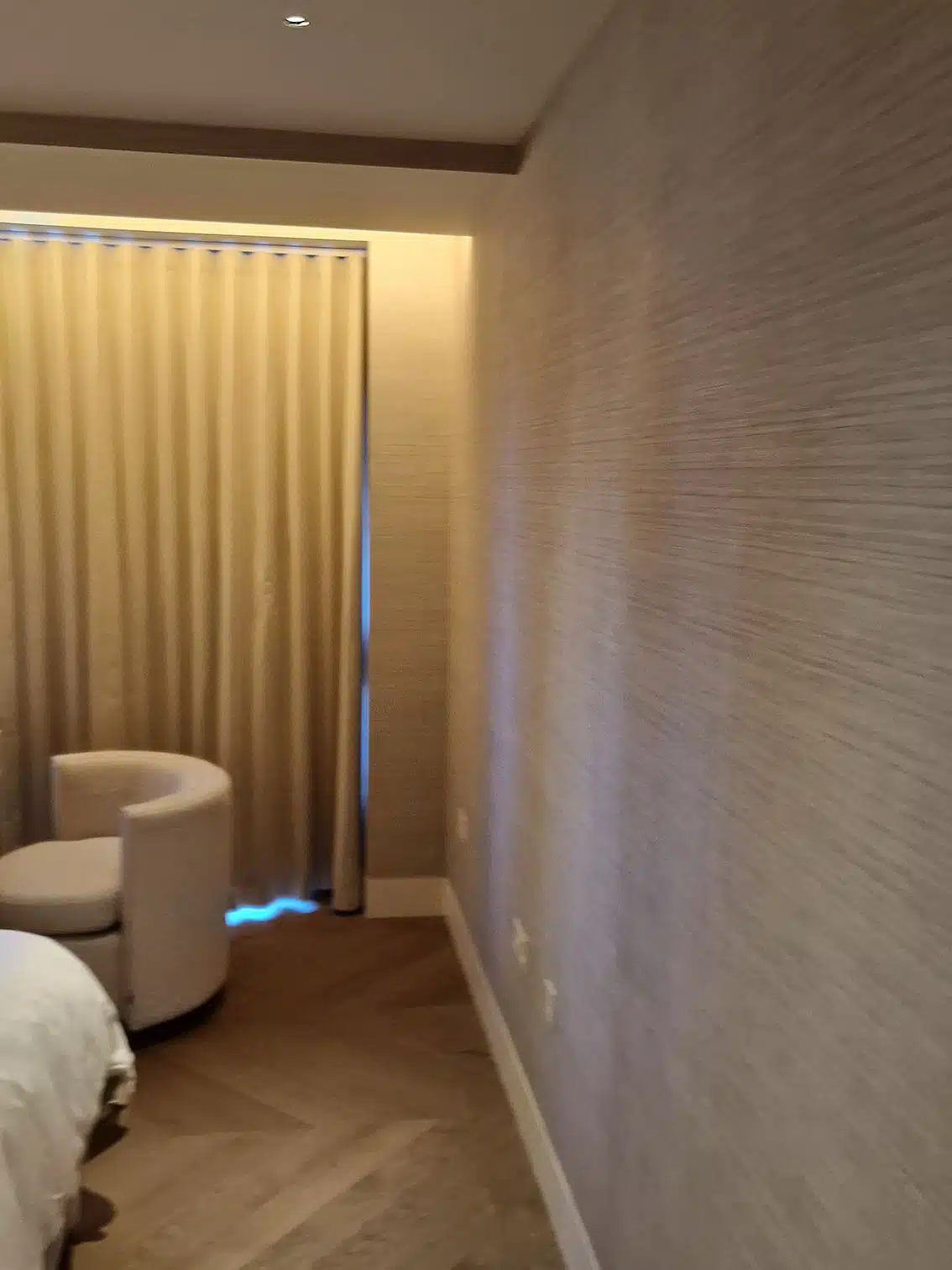 Grasscloth texture detail in a luxury bedroom with herringbone floor, installed by Mancini Wallpapers