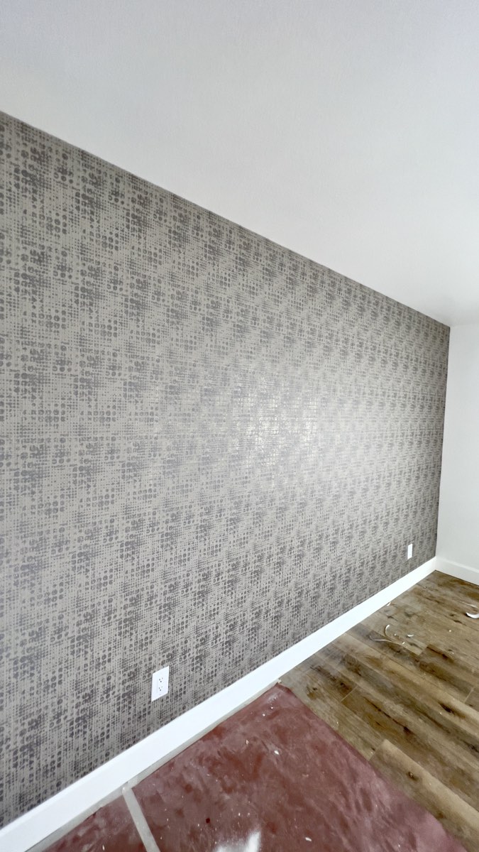 Gray textured accent wall in a new-construction home, installed by Mancini Wallpapers