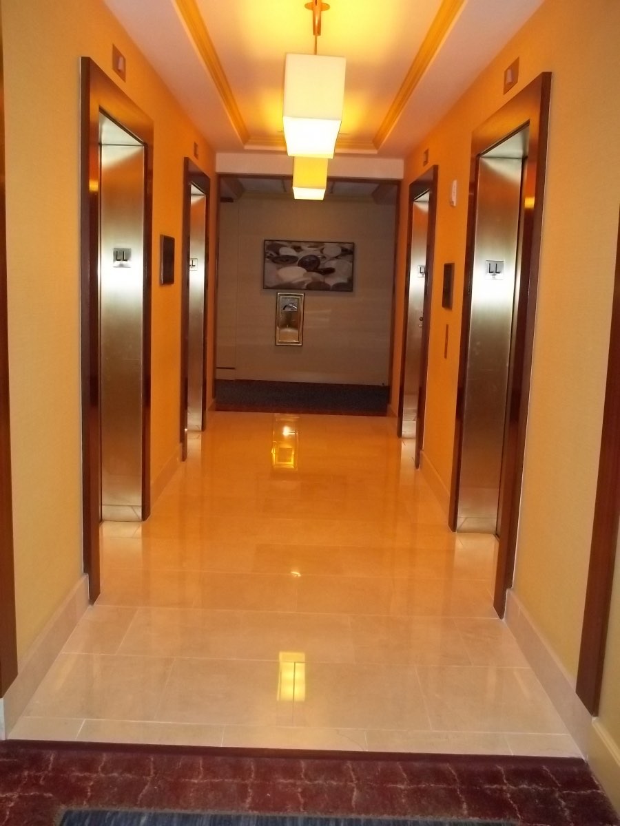 Hotel elevator corridor with contract vinyl wallcovering and polished floor, installed by Mancini Wallpapers