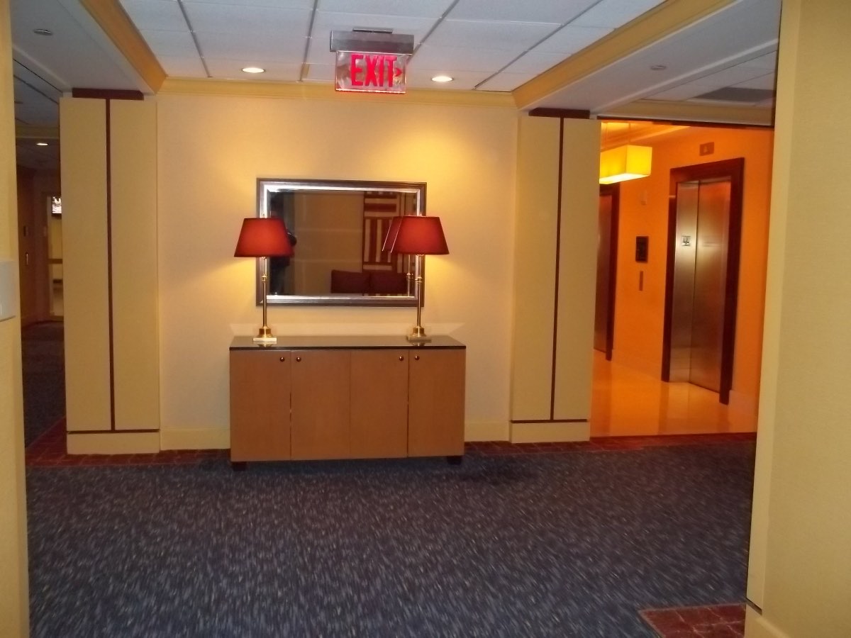Hotel hallway and elevator area in neutral contract wallcovering, installed by Mancini Wallpapers