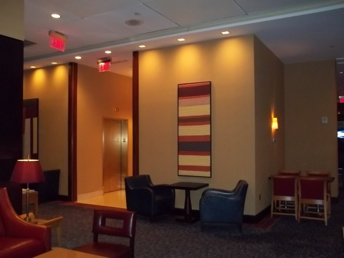 Hotel lobby seating area in warm-tone contract wallcovering, installed by Mancini Wallpapers